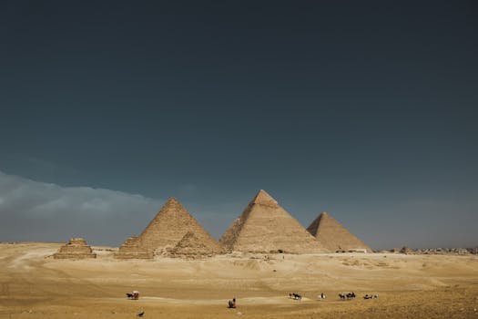 Explore the iconic Pyramids of Giza in Egypt, captured under a wide desert sky.